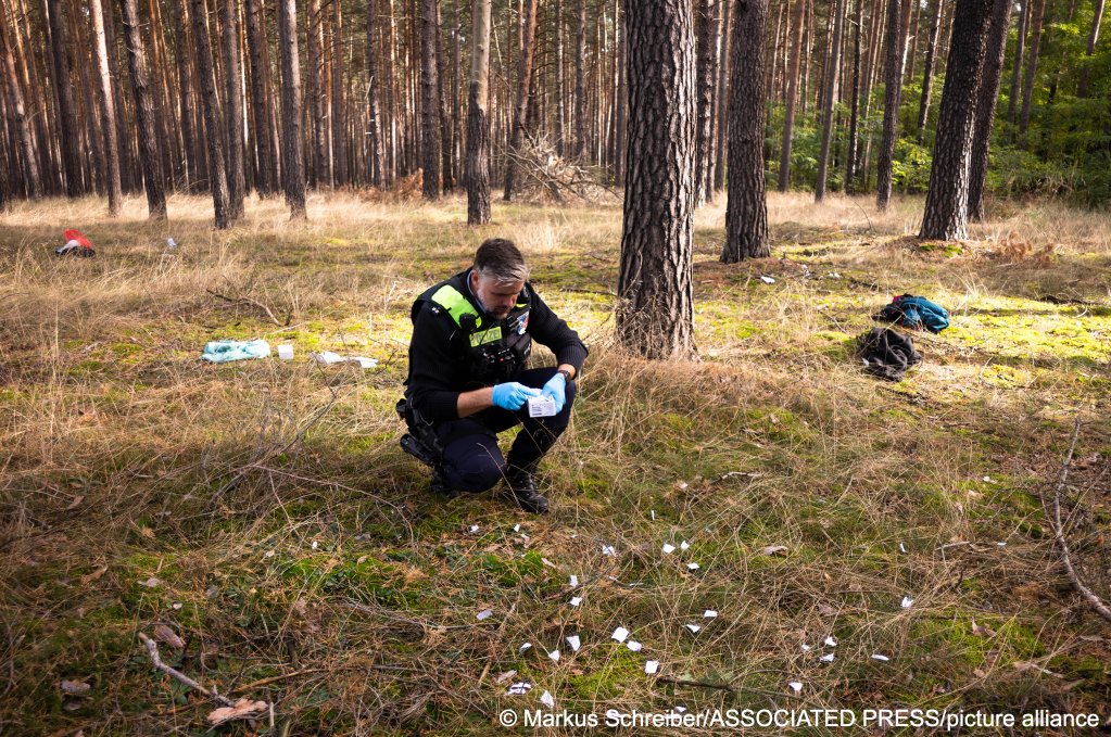 From file: A German police officer collects pieces of ripped documents from migrants who crossed the border from Poland into Germany in October 2023 | Photo: Markus Schreiber / Associated Press / picture alliance