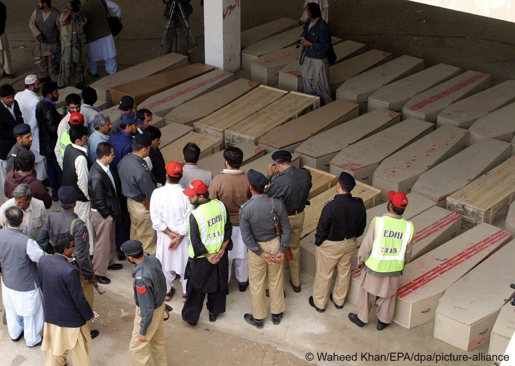 People prepare coffins containing bodies of the victims of human smuggling, in Quetta, Pakistan on April 6, 2009, as thy are being sent to Afghanistan | Photo: Waheed Khan
