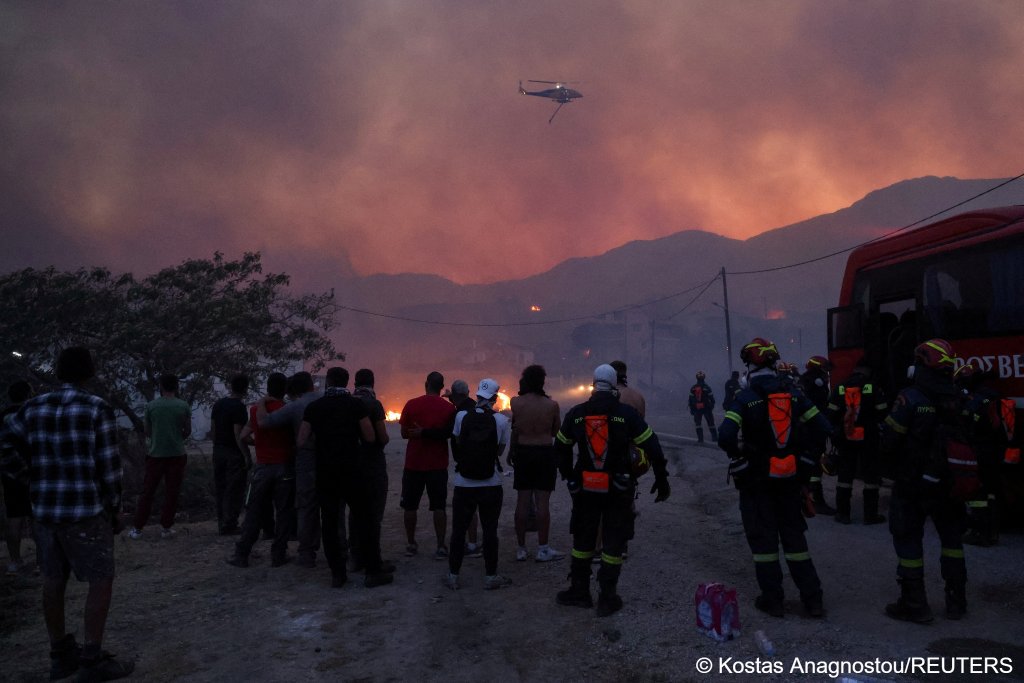 Firemen and locals look at a heliucopter near the village of Karyes on the Greek island of Chios on June 22, 2025 | Photo: Kostas Anagnostou/Reuters