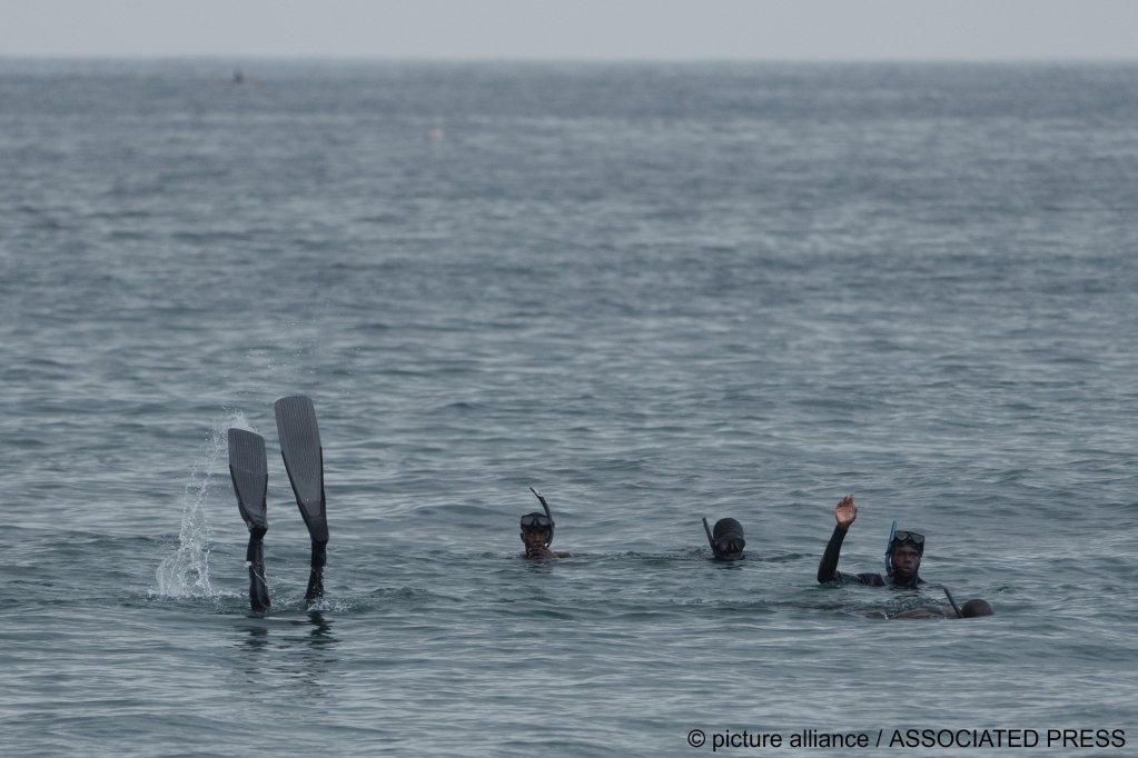 Rescuers search in the water after a boat capsized leaving several deaths at a beach in Dakar, Senegal on July 24, 2023 | Photo: Leo Correa/AP/picture-alliance