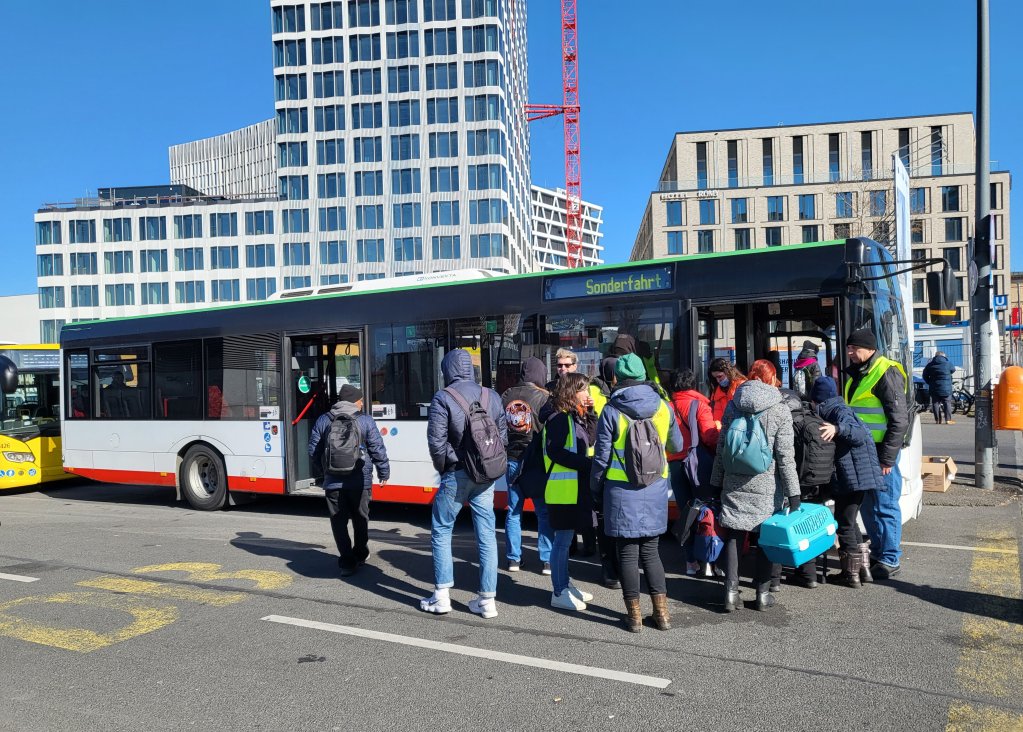 Amanuel and his father (on the far left with backpacks) board a special bus in front of Berlin's main train station on March 7, 2022 | Photo: Benjamin Bathke/InfoMigrants