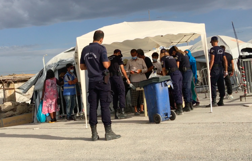 La police fouille les demandeurs d’asile à l’entrée du camp de Lesbos | Photo : Marion MacGregor / InfoMigrants