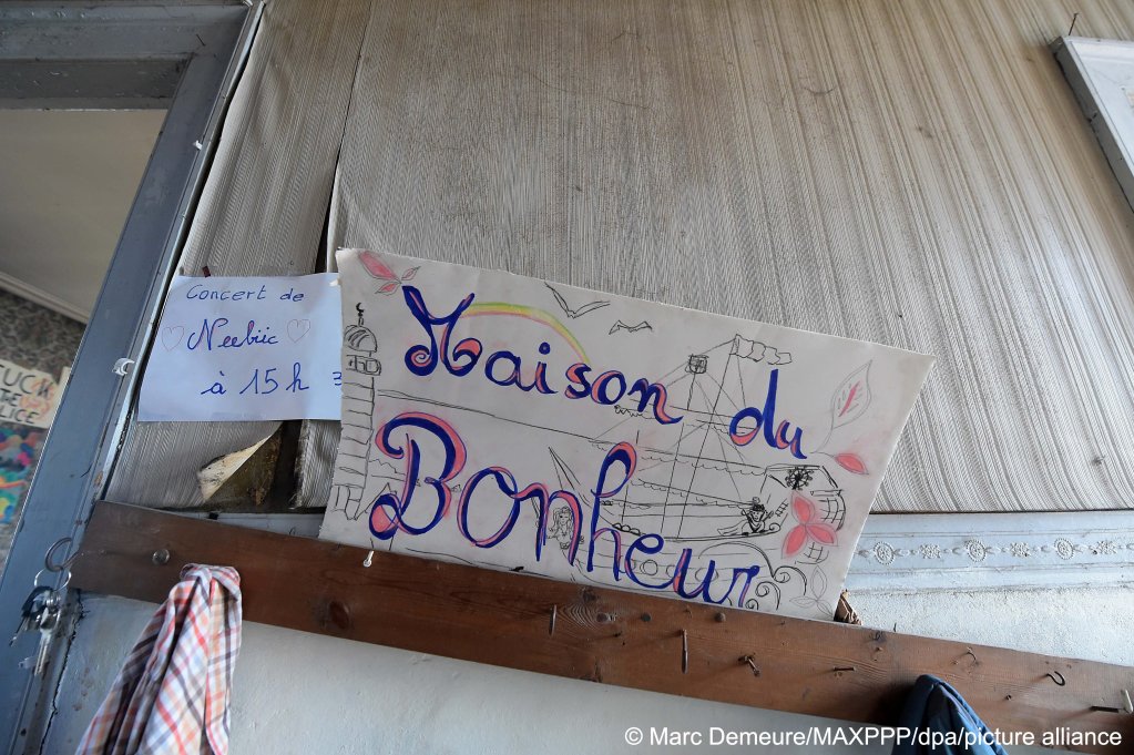 'House of Happiness' reads the sign pinned up in the squat in Calais | Photo: Marc Demeure / MAXPPP/ dpa / picture alliance