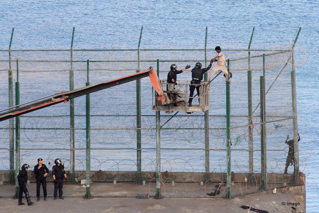 Un inmigrante fue detenido por la policía en una grúa el 30 de agosto de 2019, cuando estaba sobre la valla fronteriza esperando para saltar con seguridad en suelo español en Ciota, un asentamiento español en el norte de África.  Violación masiva de la valla fronteriza, más de 150 migrantes pudieron entrar en España desde Marruecos |  Crédito: Imago / Reduan Tris Recracui