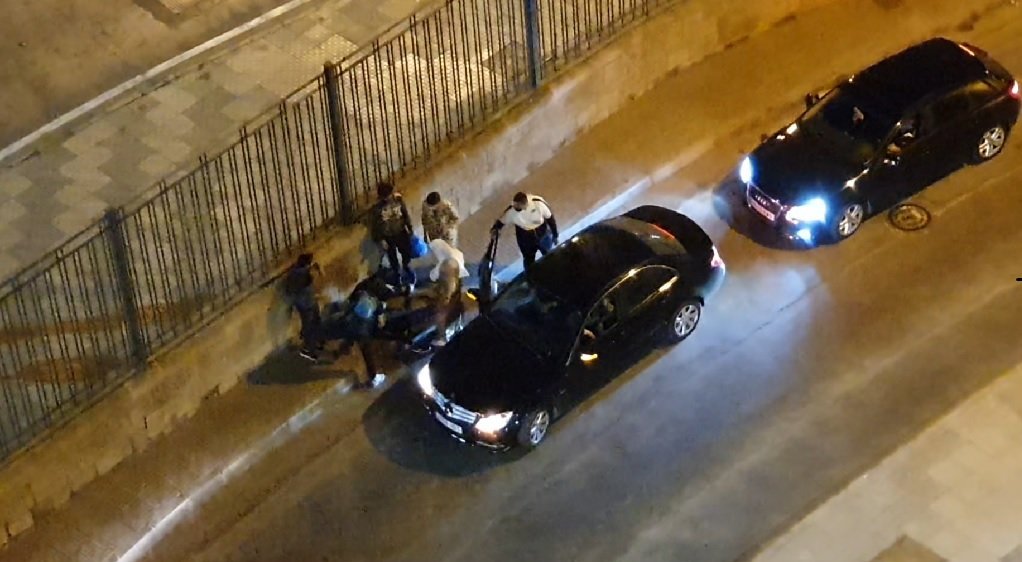 سيارات تتوقف بمحاذاة رصيف حيث يستلقي أحد المهاجرين القاصرين وهو ينزف، نتيجة ضربه من قبل أحد عناصر الشرطة، 20 أيار/مايو 2021. شريف بيبي/مهاجر نيوز
