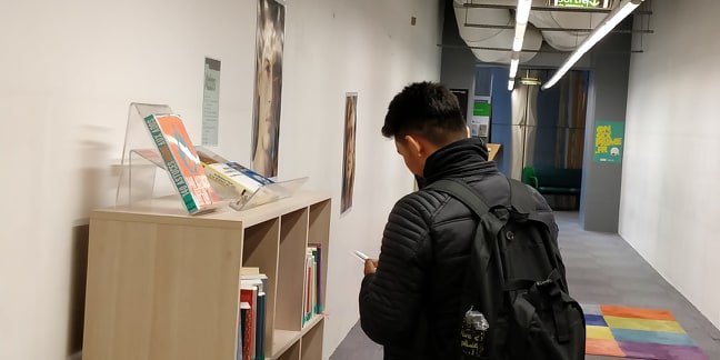 مهاجر يتصفح كتابا في إحدى المكتبات. المصدر: مهاجر نيوز