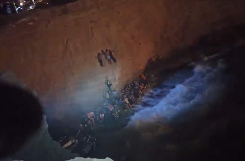 Les naufragés au pied d'une falaise de Cythère attendent d'être secourus. Crédit : capture d'écran/garde-côtes grecs