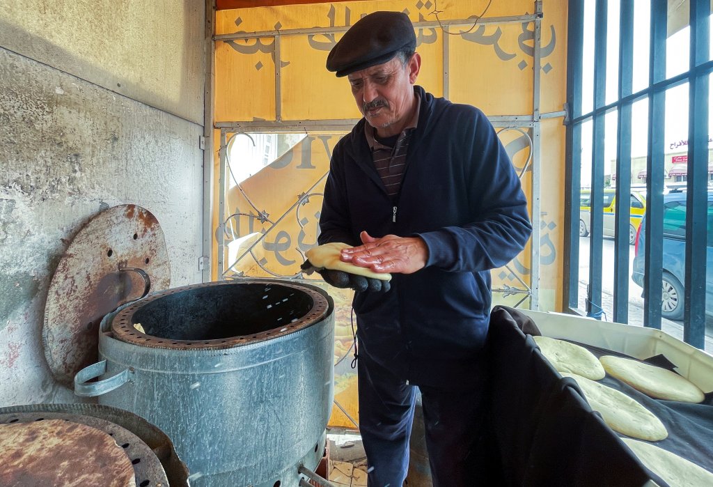 Lotfi Ajmi cuit du pain à l'aide d'un four traditionnel, dans sa boulangerie à Tunis, le 21 mars 2022. Crédit : Reuters