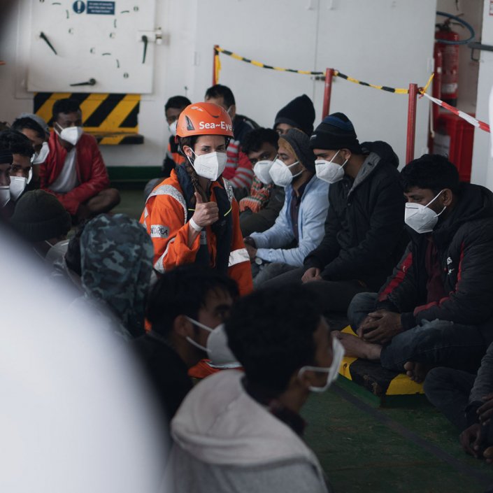 A picture of some of the rescued migrants being briefed by a Sea-Eye 4 crew member | Photo: Joe Rabe / Sea Eye Org (Twitter feed @seaeyeorg)
