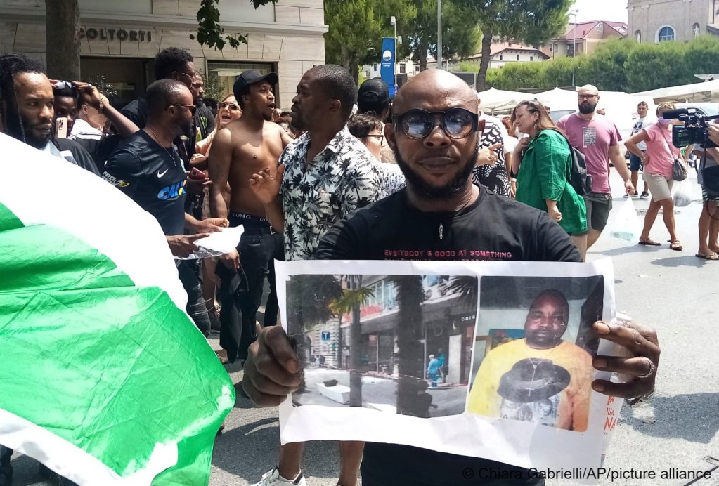 A man shows a picture of the victim Nigerian street vendor Alika Ogorchukwu, in Civitanova Marche, Italy, Saturday, July 30, 2022 | Photo: Chiara Gabrielli / picture alliance / AP