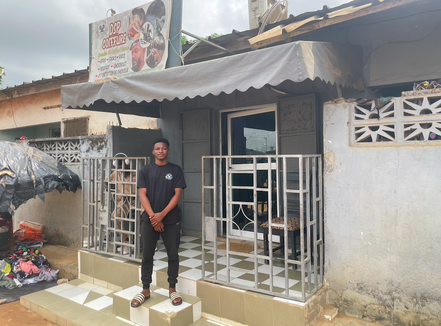 Sie, devant son salon de coiffure à Abobo, un quartier pauvre d'Abidjan. Crédit : InfoMigrants