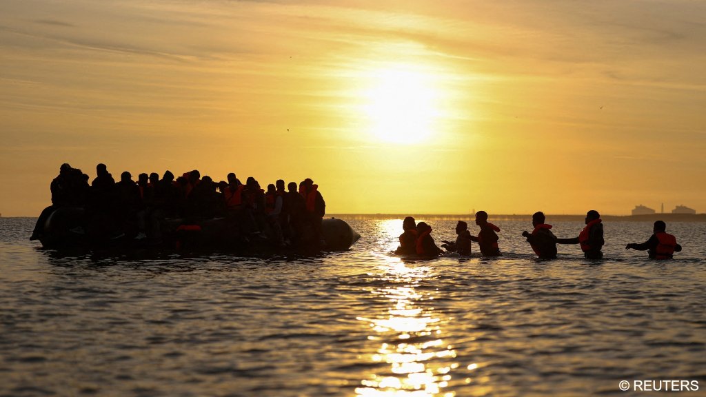 A group of migrants walk into the water to reach an inflatable dinghy in an attempt to leave the coast of northern France and to cross the English Channel to reach Britain as tougher migration controls were announced, at the beach of Petit-Fort-Philippe in Gravelines, near Calais, France, July 17, 2025 | Photo: Reuters