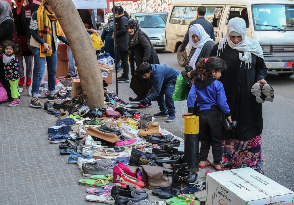 People check for clothes and shoes donated by citizens for poor families in front of the central bank in Beirut, Lebanon on July 7, 2020 | Photo: EPA/Nabil Mounzer