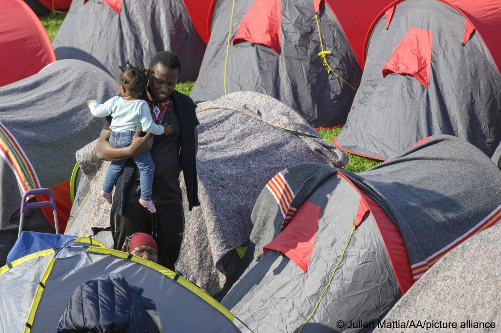 A young man and a toddler at a migrant protest camp in Paris, France on September 1, 2021 | Photo: Julien Mattia/AA/picture-alliance