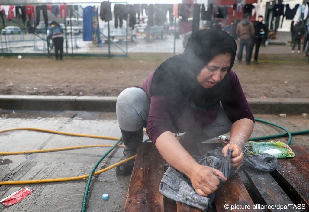  A refugee woman handwashes clothes at the Bruzgi Transport and Logistics Centre on November 22, 2021 | Photo: Sergei Bobylev/TASS/dpa/picture-alliance