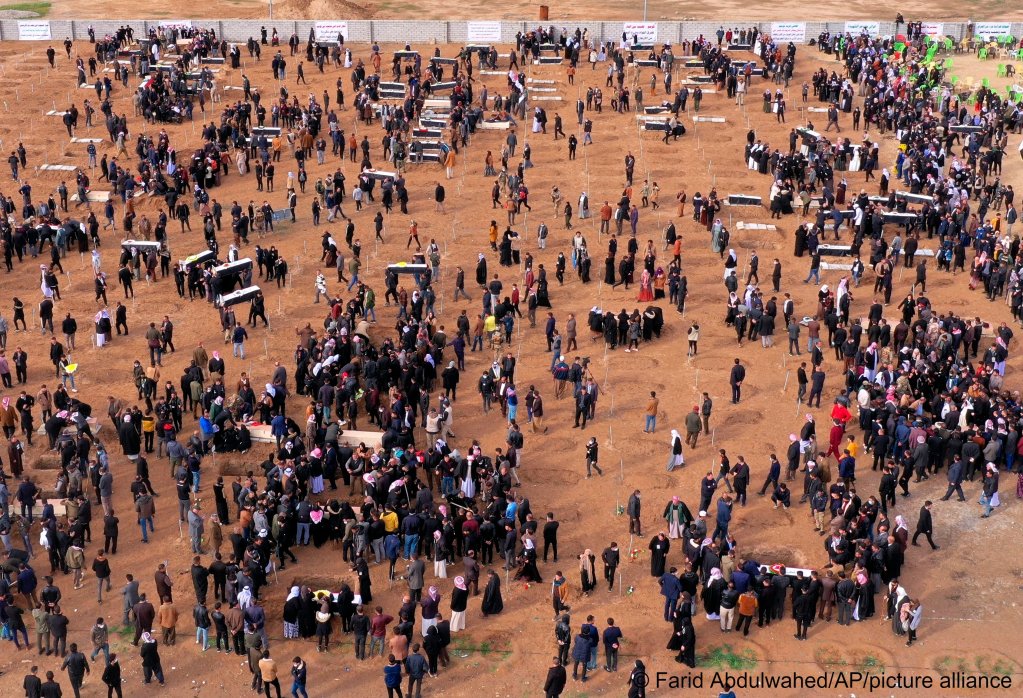 Aerial view of mourners preparing to bury the remains of 104 Yazidi victims in a cemetery in the village of Kocho in Iraq's northern Sinjar region on February 6, 2021. The Yazidis were killed by the IS terror militia in 2015. The bodies were exhumed from mass graves in 2020 with the coordination of the United Nations Investigative Team to Promote Accountability for Crimes Committed by IS | Photo: Farid Abdulwahed/AP